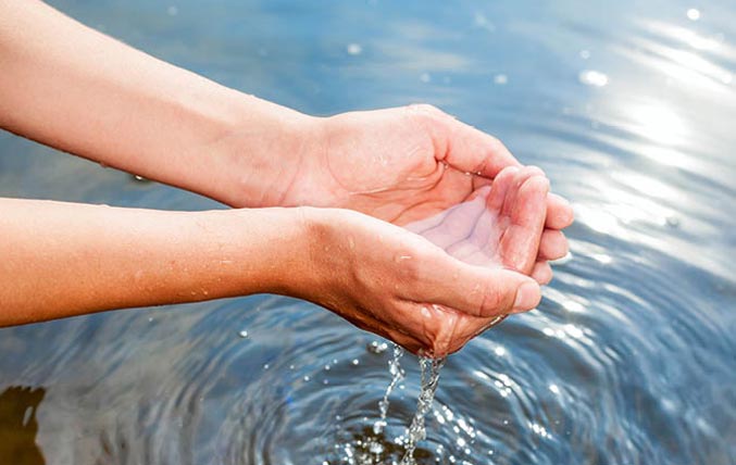 Dos manos ahuecando agua entrante/natural 